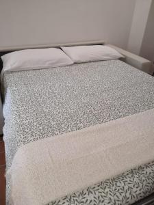 a bed with a white bedspread and pillows on it at ficodindia Suite & Apartments in Santo Stefano di Camastra