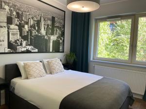 a bedroom with a bed with a black and white picture on the wall at River View Old Town in Gdańsk