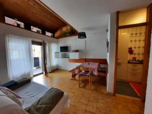 a living room with a table and a dining room at Appartamento Fiorella in San Martino di Castrozza