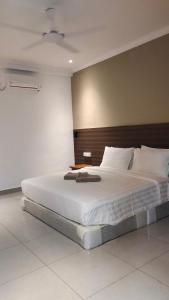 a bedroom with a large bed with a wooden headboard at Hemingway Cottage 海明威度假屋 in Semporna