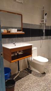 a bathroom with a sink and a toilet at Hemingway Cottage 海明威度假屋 in Semporna