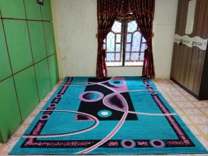 a room with a peacock rangoli on the floor at Komodo homestay in Komodo