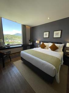 1 dormitorio con 1 cama grande y ventana grande en Suni Hotel and Convention Abepura managed by Parkside en Tobadi
