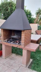 een steenoven op een bankje in een tuin bij villa climatisée avec grande piscine in Saint-Laurent-de-la-Salanque