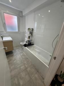 ein Bad mit einer Badewanne, einem WC und einem Fenster in der Unterkunft 269 Main Street 3 bedrooms Gem in Gibraltar