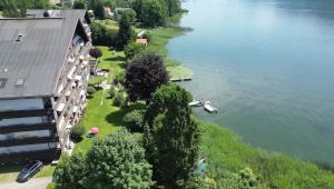 arial view of a river with a building and a house at PETER Seeblick Appartement Haus Hänsel Gretel am Ossiacher See, Hallenbad, Skiarena Gerlitzen in Unterberg
