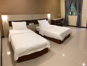 a hotel room with two beds and a window at Hemingway Cottage 海明威度假屋 in Semporna