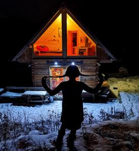 a person standing in front of a cabin at night at Srub Pod Lípou - Skryje 