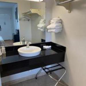 baño con encimera negra con lavabo y espejo en Motel 6-Van Horn, TX, en Van Horn