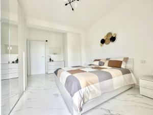 a bedroom with a bed and white walls and marble floors at casa la Rosa in Lesa