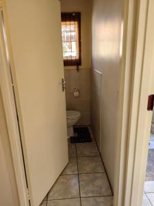 baño con aseo y ventana en Thandanani Serene place, en Pietermaritzburg