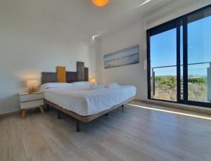 een slaapkamer met een groot bed en een groot raam bij AL048 Pinada Beach IV La Mata in La Mata