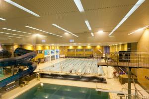 a large swimming pool with a pool slide in a building at 35 Quaker Lane in Darlington