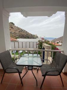 a patio with a table and two chairs on a balcony at Oros Eros 2 in Hydra