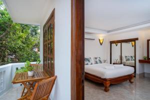 1 dormitorio con 1 cama y balcón en River Retreat Boutique Hotel, en Siem Reap