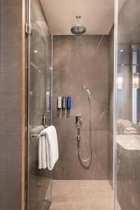 a bathroom with a shower and a sink at Novotel Chandigarh Tribune Chowk in Chandīgarh