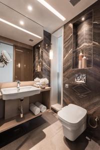a bathroom with a white toilet and a sink at Novotel Chandigarh Tribune Chowk in Chandīgarh
