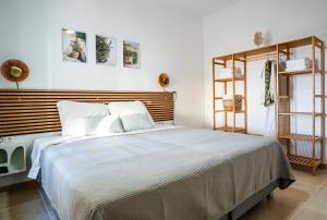a bedroom with a large bed with a wooden headboard at Azula Luxury Apartments in Parikia