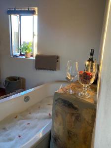 a bathtub with two glasses and wine bottles on it at Herdade da Maceira in São Luis