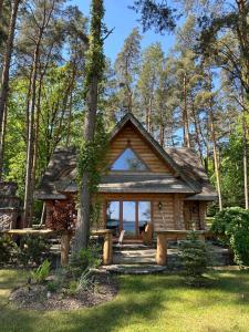 a log cabin in the woods with a tree at Cedrowa Villa - Rezydencja nad jeziorem in Ełk