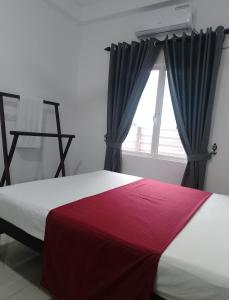 a bedroom with a large bed with a window at Laxsume Guest House Nilaveli in Nilaveli