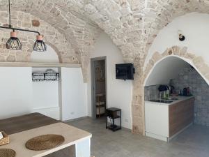 a kitchen with two arches and a table in a room at Franco Deluxe home in Ceglie Messapica