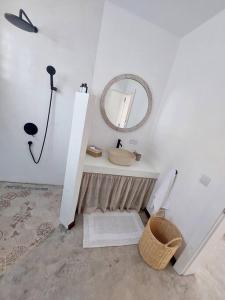 a bathroom with a sink and a mirror and a toilet at AO Cottage in Petite Case Noyale +12 photos