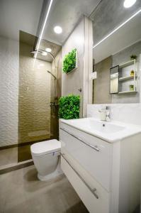 a white bathroom with a toilet and a sink at Northern Horizon in Voluntari +19 photos