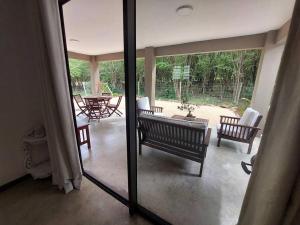 a living room with two benches and a patio at AO Cottage in Petite Case Noyale