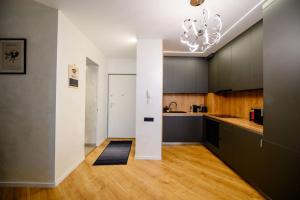 a large kitchen with black cabinets and a chandelier at Northern Horizon in Voluntari