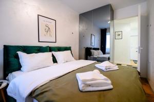 a bedroom with a large bed with towels on it at Northern Horizon in Voluntari