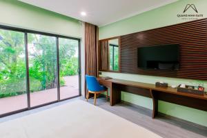 a bedroom with a desk and a tv on a wall at Quảng Ninh Gate Hotel & Resort in Bác Mã