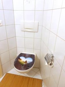 a bathroom with a toilet with the seat up at Ferienwohnung Romantica in Felsberg +14 photos