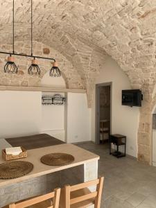 a kitchen with a stone wall and a table and chairs at Franco Deluxe home in Ceglie Messapica