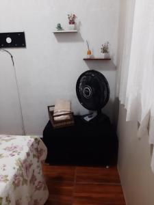 a room with a bed and a fan on the floor at Loft aconchegante - Centro Niterói in Niterói