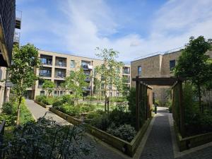 um pátio com um jardim em frente a um edifício em Luxury 1-Bed Apartment with balcony & Free parking em Milton Keynes