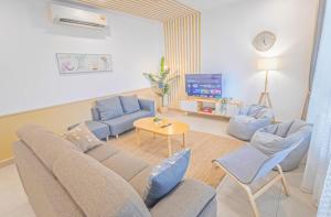 Una sala de estar con un sofá y sillas y un televisor. en KL Gateway Residences, en Kuala Lumpur