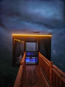 a deck with a view of the ocean at night at Northland Bungalows in Çayırdüzü