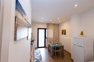 a small kitchen with a table and a refrigerator at A Casa di Amici Apartment in Giardini Naxos +3 photos