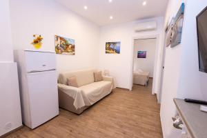 a living room with a chair and a refrigerator at A Casa di Amici Apartment in Giardini Naxos