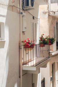 a balcony with flower pots on a building at A Casa di Amici Apartment in Giardini Naxos