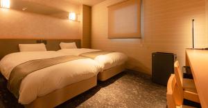 Säng eller sängar i ett rum på Matsumoto Tourist Hotel