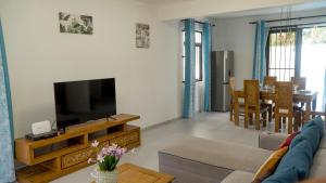 a living room with a couch and a television at Garuda Villa in Trou aux Biches