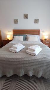 uma cama grande com duas almofadas brancas em ÁTICO Vilagarcía em Vilagarcía de Arousa
