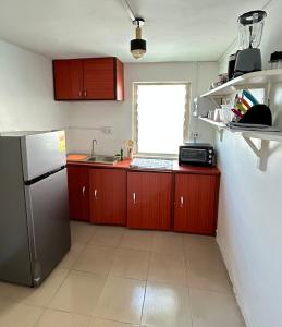 uma cozinha com um frigorífico e um lavatório em Big & confortable house in Oxford street Barnor em Acra