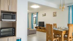 cocina y sala de estar con mesa y microondas en Garuda Villa en Trou aux Biches