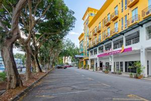 een straat in een stad met gele en witte gebouwen bij Kings Hotel Melaka in Melaka