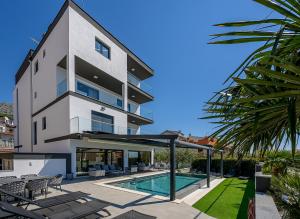 a building with a swimming pool and a house at Villa Nani in Podstrana