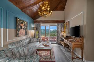 a living room with a couch and a table and a television at juSTa Birding Resort & Spa - Best Dhauladhar View Resort in Dharamshala