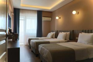 ein Hotelzimmer mit 3 Betten und einem Fenster in der Unterkunft Otel 57 in Sinop